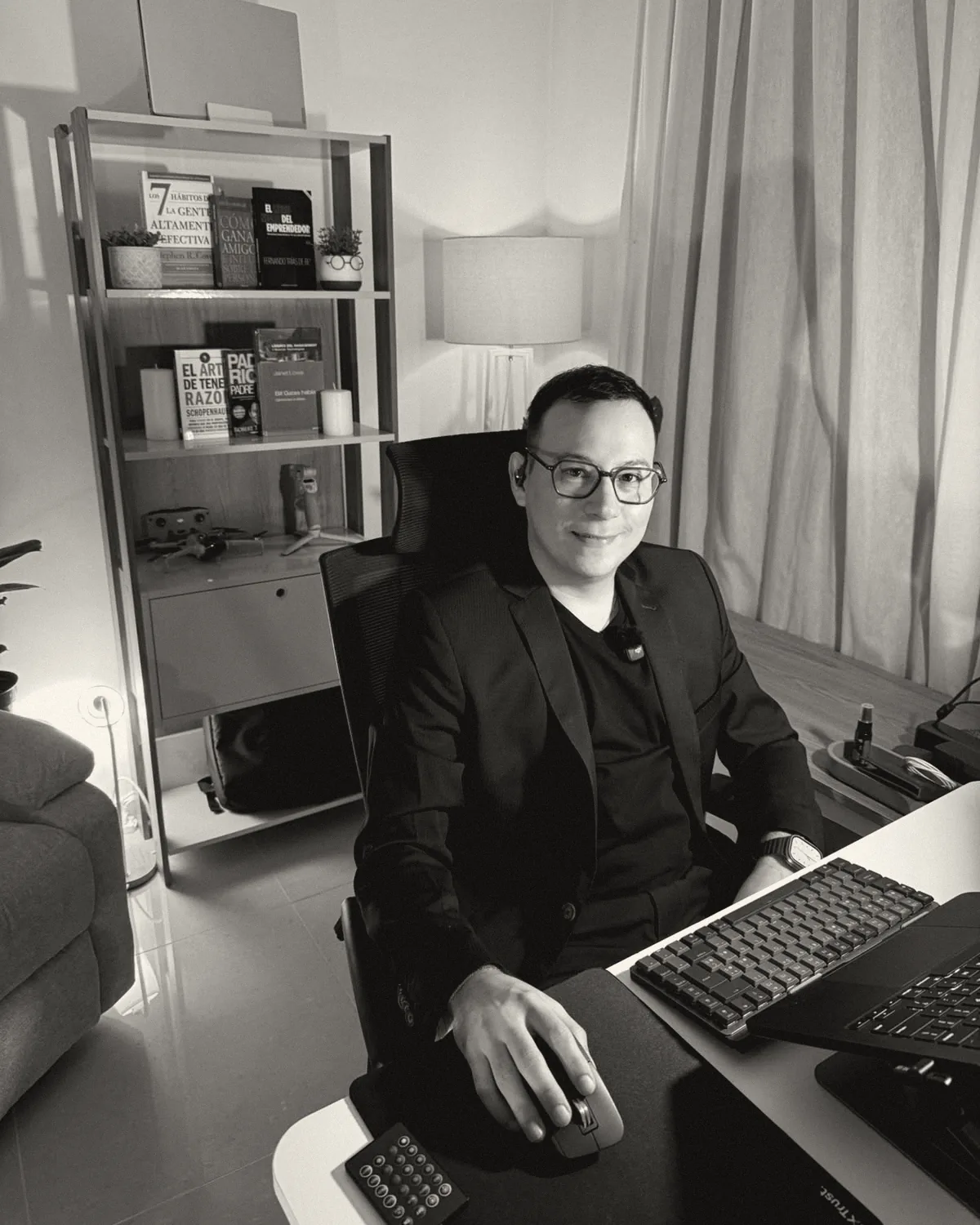 Frank Sánchez trabajando en el escritorio de su despacho, junto a la estantería y la lámpara